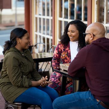 A family happily chatting at an outdoor café.