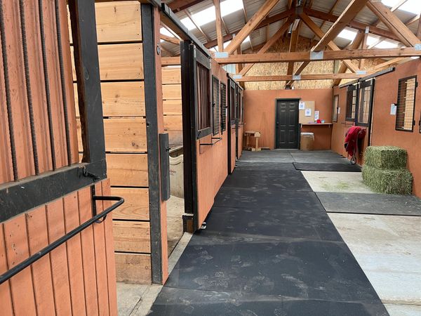 Alley of small barn with Airbnb stalls on the left.