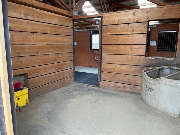 Airbnb stall with water and feed bin.