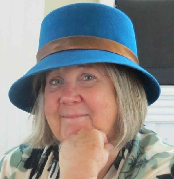 Jane Elzey wearing a blue hat and patterned shirt.