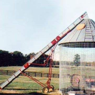 Corn elevator pushed up against round wire corn crib