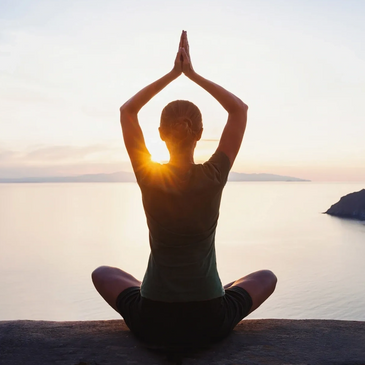 Silhouette of individual meditating during sunset 