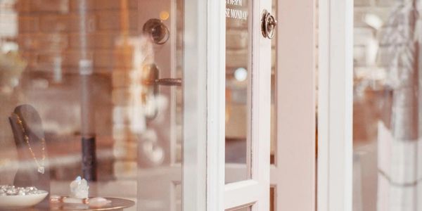 Elegant jewelry displayed inside a store behind a glass door.