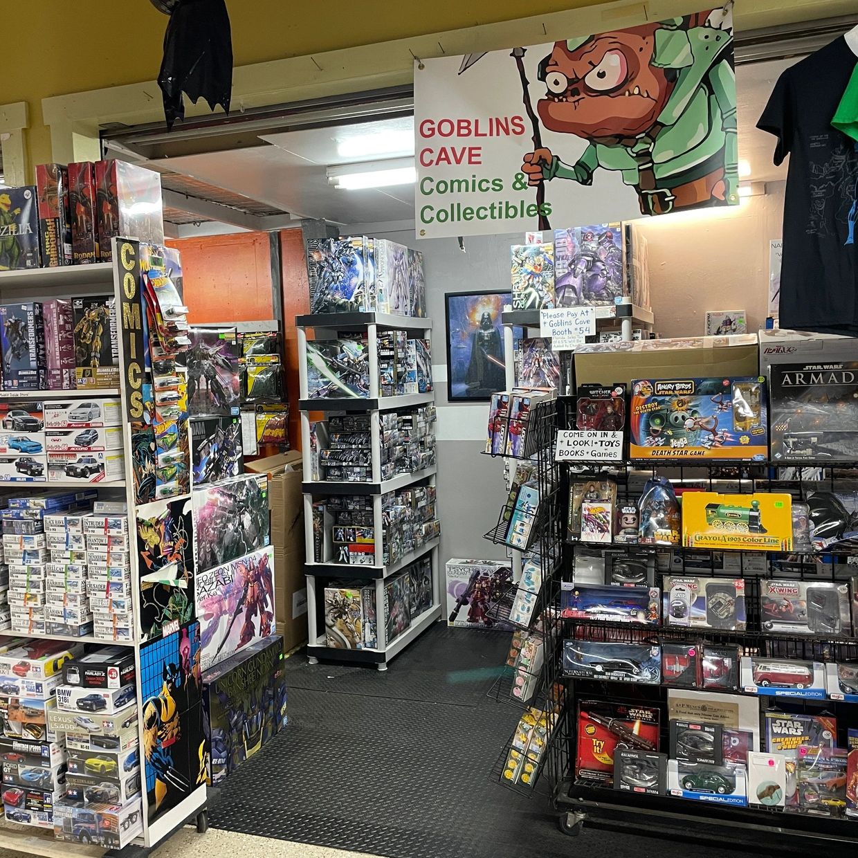 Shelf filled with collectible figurines, trading cards, and RPG gear.