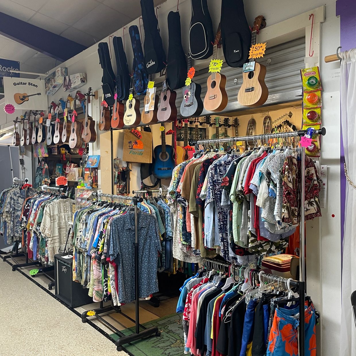 Wall display of ukuleles and acoustic guitars in various finishes.