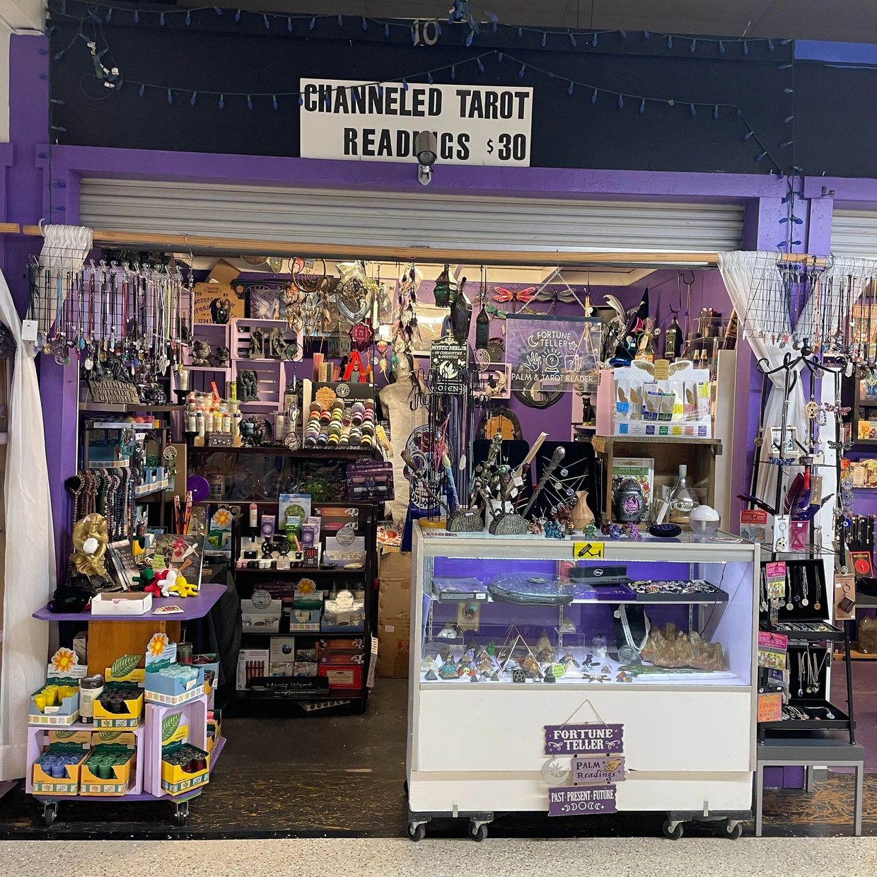 Decorative shelves filled with crystal spheres, incense, and metaphysical tools.