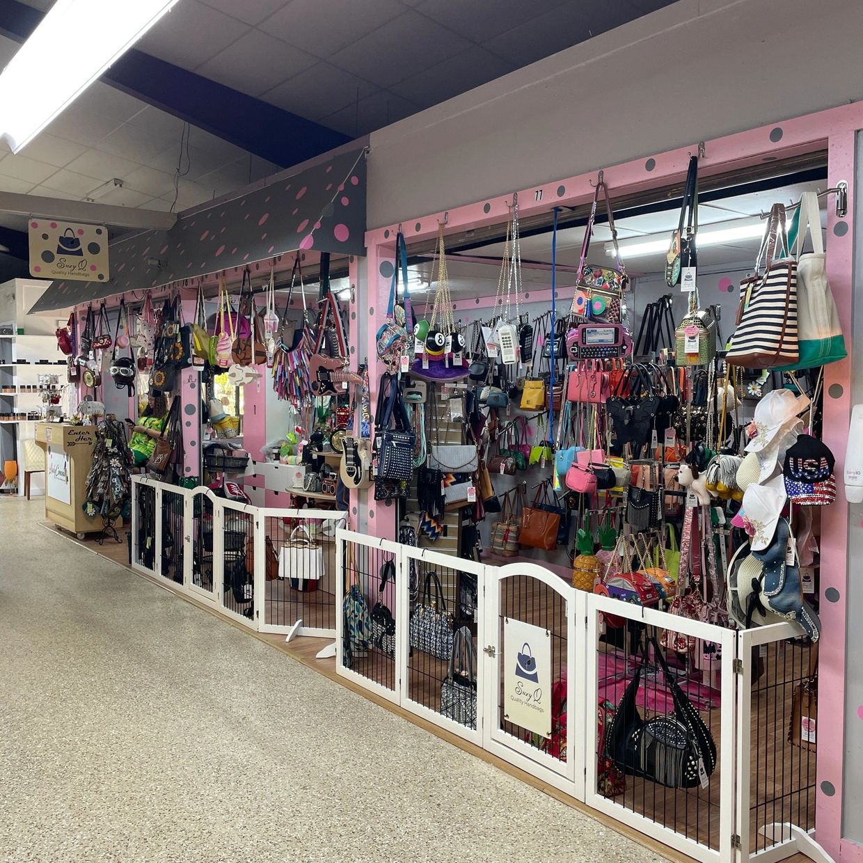 Trendy handbags displayed on hooks and wooden shelving at Suzy Q’s.