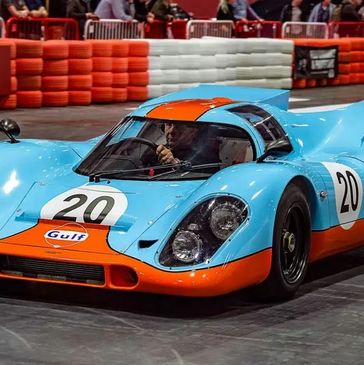 Classic blue and orange Gulf race car with number 20 on track.