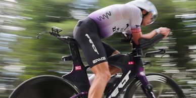 Cyclist riding a time trial bike at high speed.