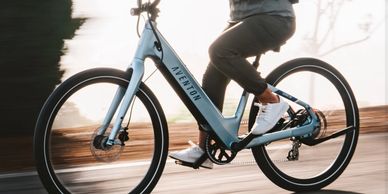 Person riding a blue Aventon bike.