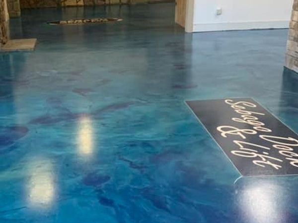 Shiny blue epoxy floor in a modern lobby with stone accents.