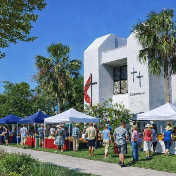 Community market event outside Cornerstone church on a sunny day.