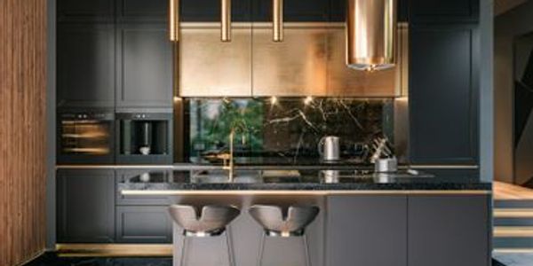Modern kitchen with dark cabinetry and gold accents.