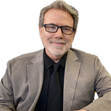 Smiling man in gray suit and black shirt with glasses.