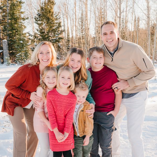 Happy family posing together outdoors in a snowy forest.