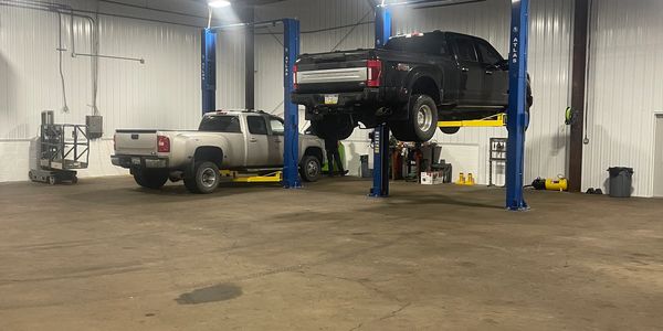 Commercial trucks being repairs inside Impact Truck Service garage
