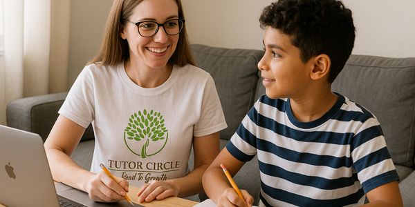 A tutor and student smiling while working on assignments together.