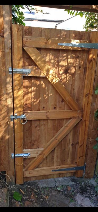 Wooden garden gate with metal hinges and latch.