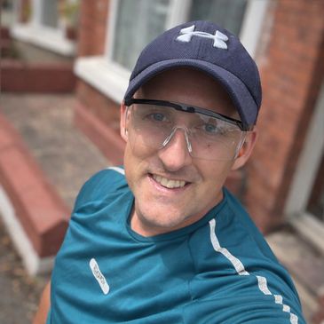 Man wearing a blue Under Armour cap and clear protective glasses.