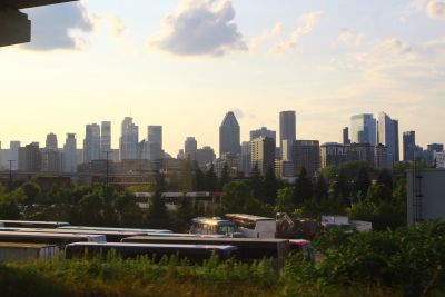 City skyline at sunset with buses in the foreground.