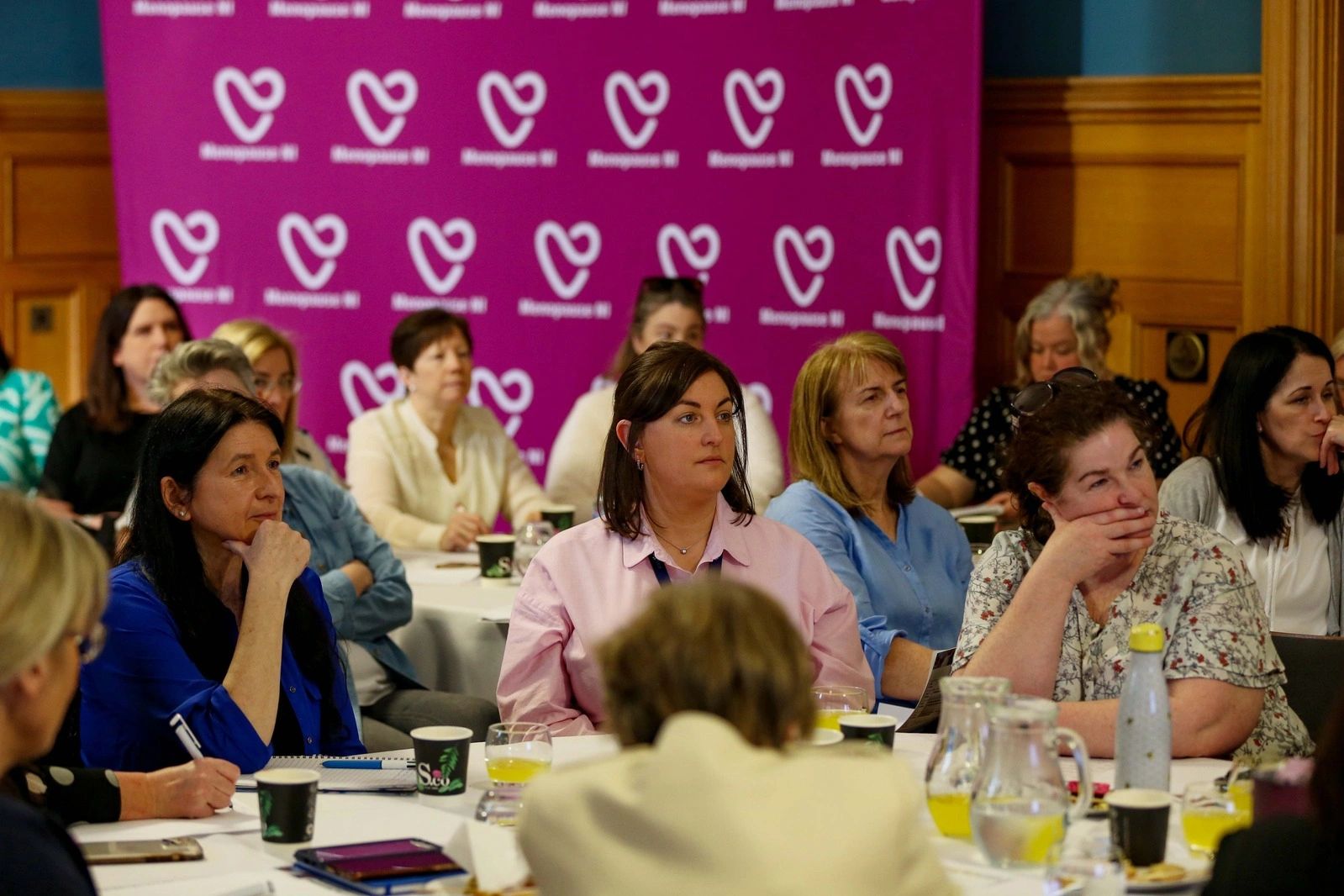 Women attentively listening at a conference or seminar.