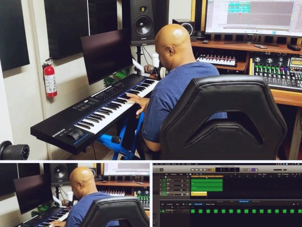 Man composing music on a keyboard in a recording studio.