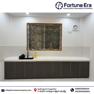 Modern kitchen countertop with sleek black faucet and window grill.