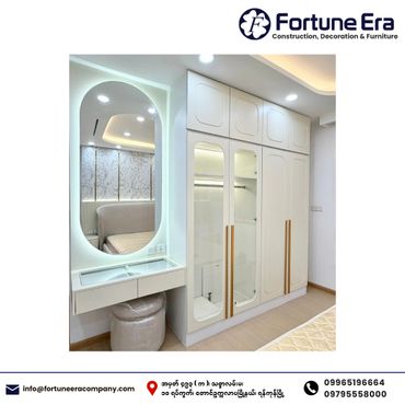 Modern white bedroom wardrobe with mirrored doors and a vanity area.