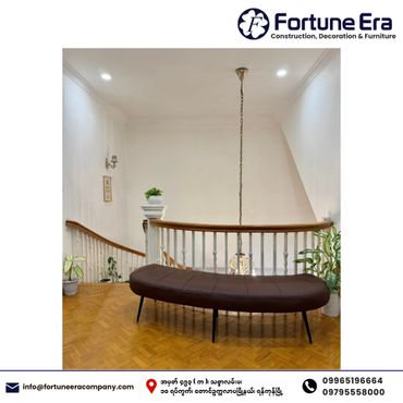 A modern brown bench in a bright, minimalist stairwell with plants.