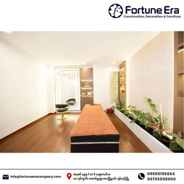 A modern, clean healing studio with wooden flooring and green plants along the wall.