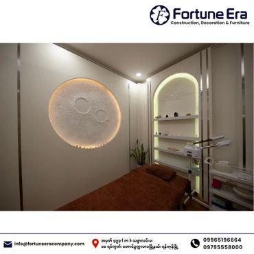 Modern spa room with a moon wall art and cozy brown treatment bed.