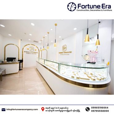 Modern jewelry store interior with white and gold decor and glass display cases.