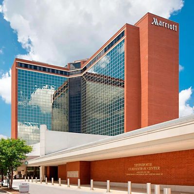 Tall Marriott hotel building with reflective glass windows.