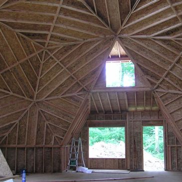 Geodesic dome shell in framing stage before framing second floor.  Second floor dormer over front do