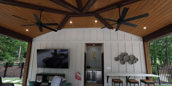 Covered outdoor patio with TV, seating, and a small bar area.