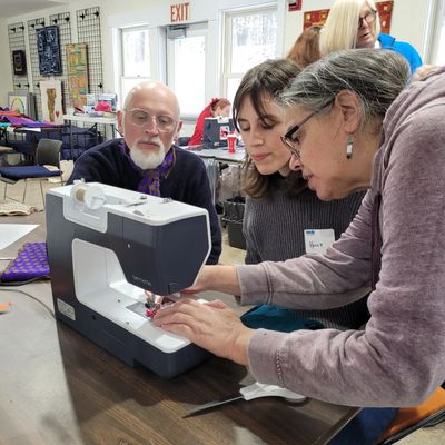 Matt, Holly, and Susan sewing winter hats in January 2026