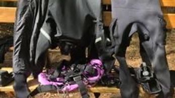 drysuits and scuba gear hanging up after a dive