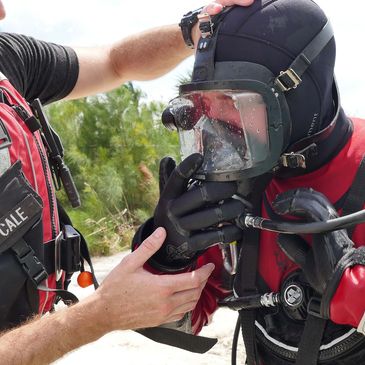 Public Safety diver in training getting the hang of a fully encapsulating suit.