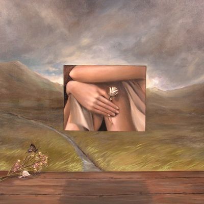 Surreal landscape with a floating framed image of hands holding a flower.