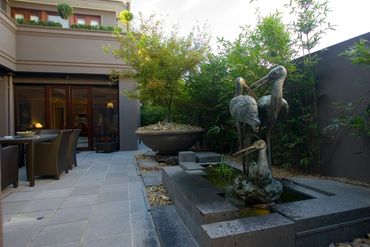 Courtyard Garden with Italian Bronze Cranes overlooking pond and large Italian bowl with feature Jap