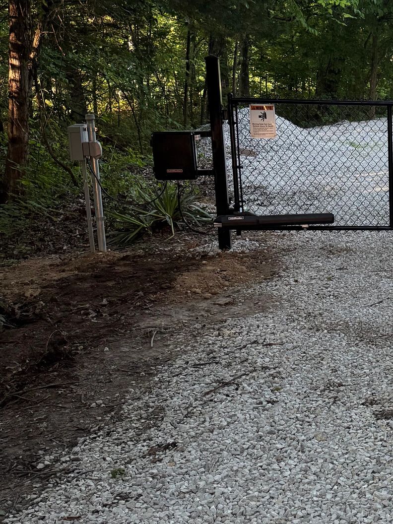 Electric gate in a wooded area.