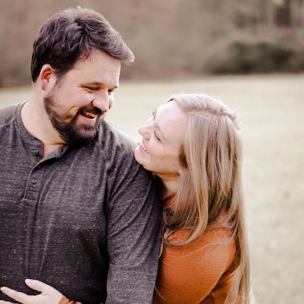 Couple embracing outdoors, sharing a joyful moment.