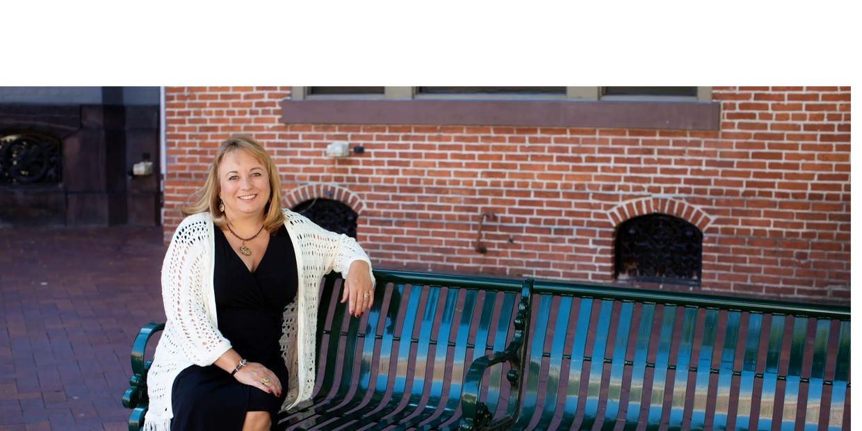 Tonya Miller sitting on a bench in front of a brick wall.