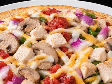 Close-up of a cheesy chicken and vegetable pizza.