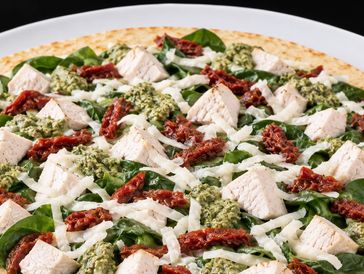 Pizza with chicken, spinach, pesto, sun-dried tomatoes, and cheese.