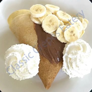 Pancake triangle with Nutella, banana slices, and whipped cream.