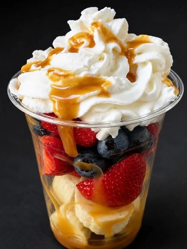 Fruit dessert with whipped cream and caramel sauce.