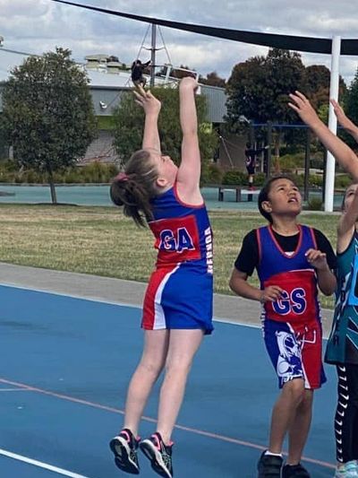 Mernda Junior Netball Player shooting a goal