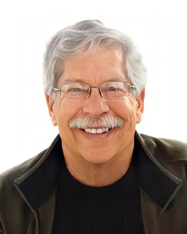Smiling older man with glasses and a gray mustache.