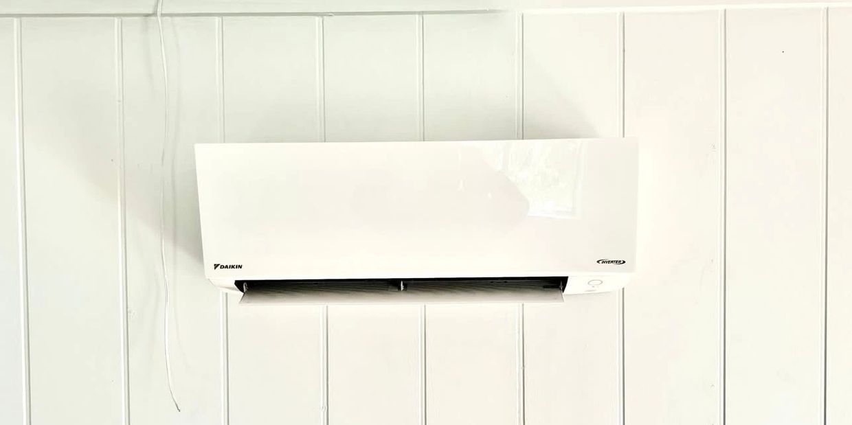Mini Split mounted on a white plank wall.